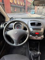 Peugeot 107 2012 — førerplads med rat og instrumenter