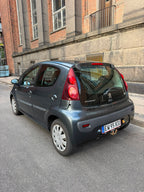 Peugeot 107 2012 i mørkegrå — set skråt bagfra